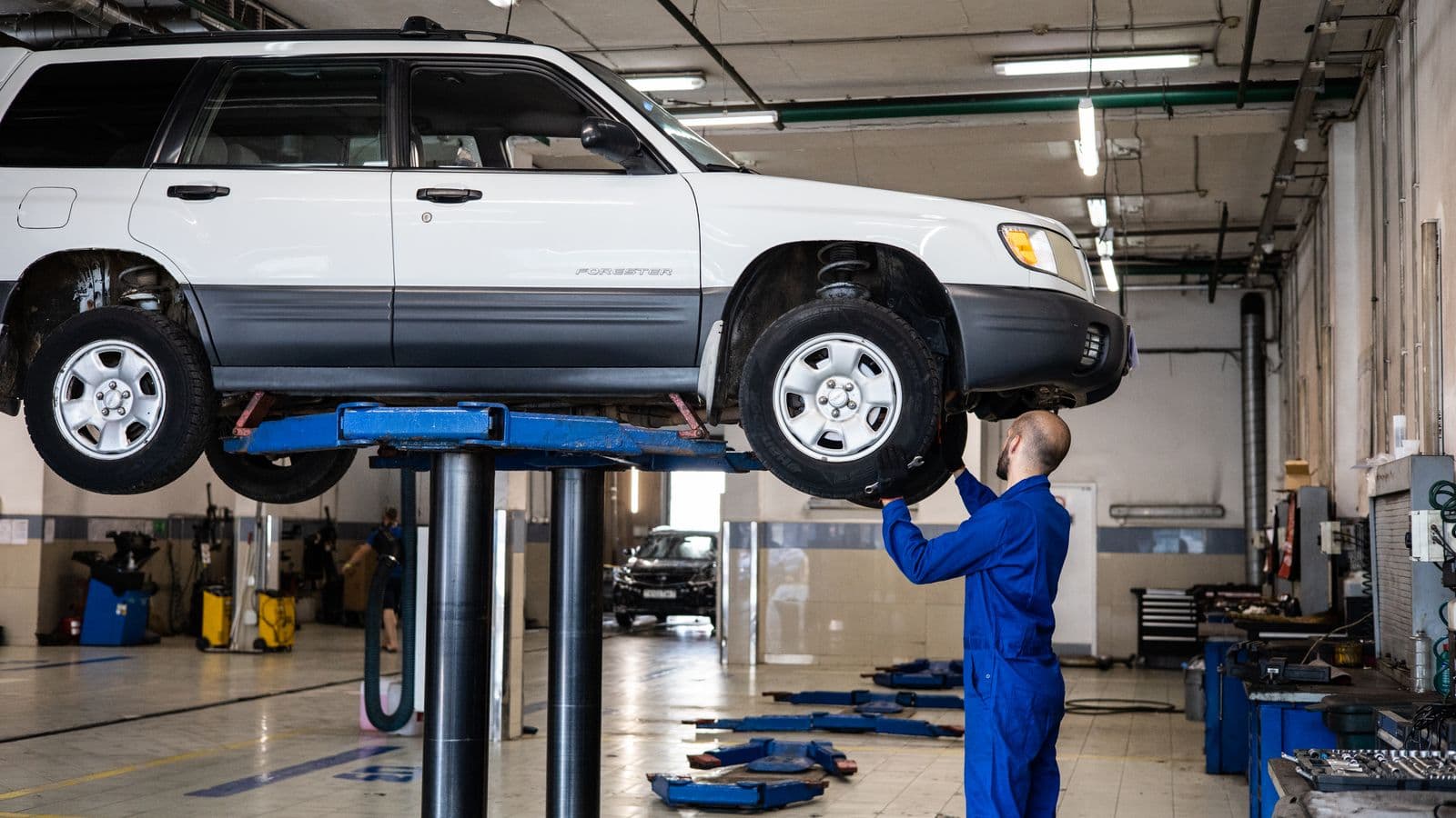 Mecânico inspecionando o motor de um carro em uma oficina